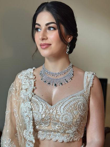 This profile shot of Oezlem shows the delicate details of her hair and makeup. The soft updo and glowing skin create a look of timeless romance.