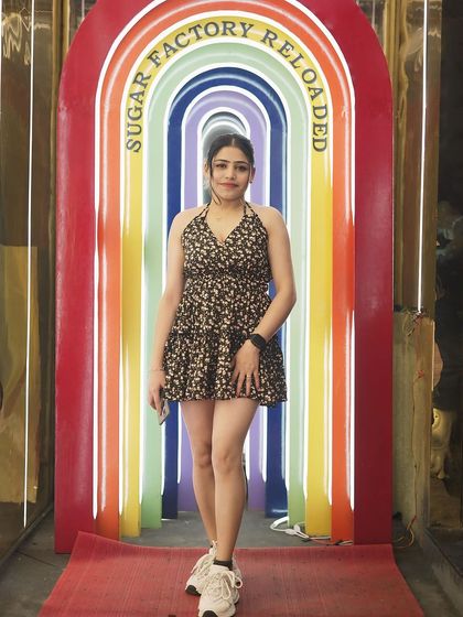 A guest posing at the venue's unique rainbow-colored entrance.