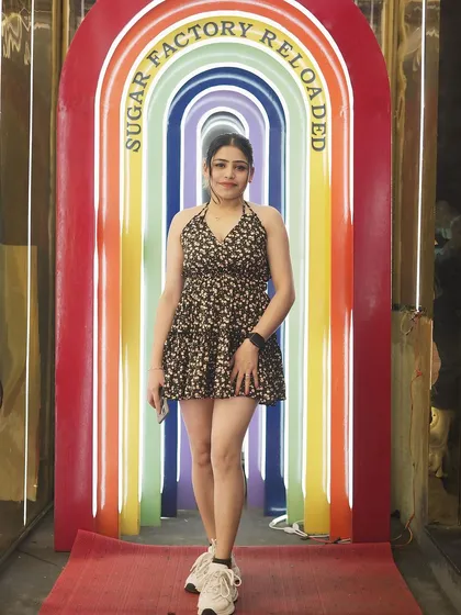 A guest posing at the venue's unique rainbow-colored entrance.