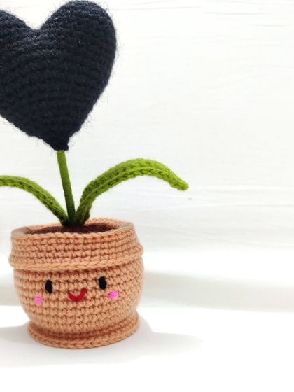 A clean shot of the black heart pot with its adorable smiley face and blush cheeks, perfect for a minimalist aesthetic.