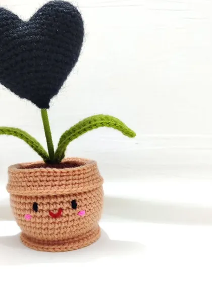 A clean shot of the black heart pot with its adorable smiley face and blush cheeks, perfect for a minimalist aesthetic.