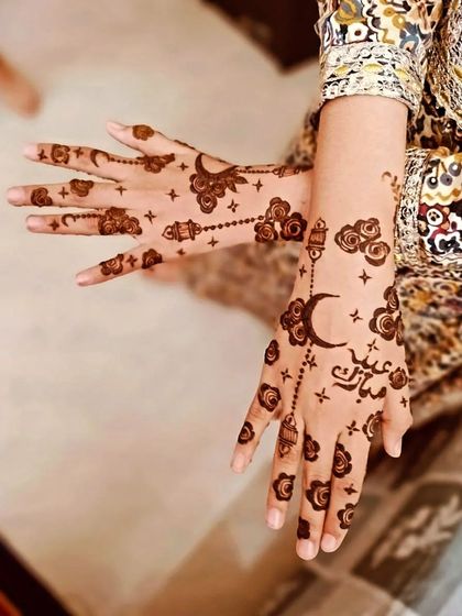 A creative pose showing off the Eid Mubarak henna.