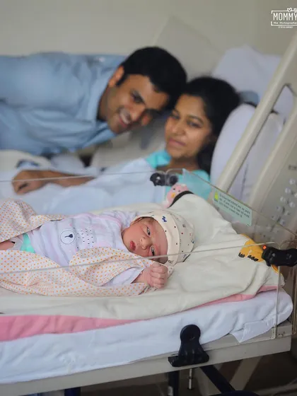 New parents admiring their baby, who is awake and looking around from the hospital bassinet. I love capturing these early moments of discovery and connection.