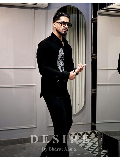 A dynamic pose in the abstract face shirt, showcasing its modern design and the confidence it inspires.