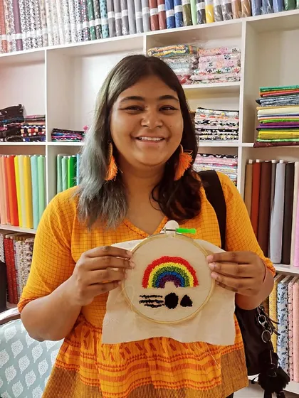 This participant is so happy with her finished rainbow hoop art, a cheerful piece to brighten any room.