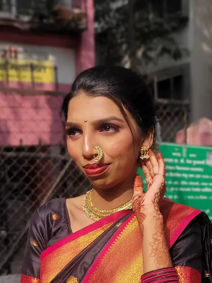 I love creating classic Maharashtrian traditional looks. This style features a warm, glowing base, defined eyes, a bold red lip, and is completed with traditional jewelry like the iconic *nath* (nose ring).