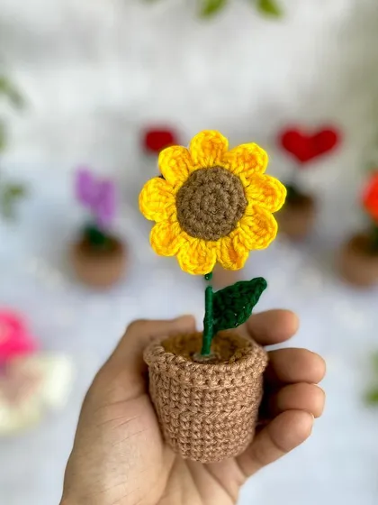 A close-up of a mini potted sunflower. It’s a little burst of sunshine for your desk or fridge.