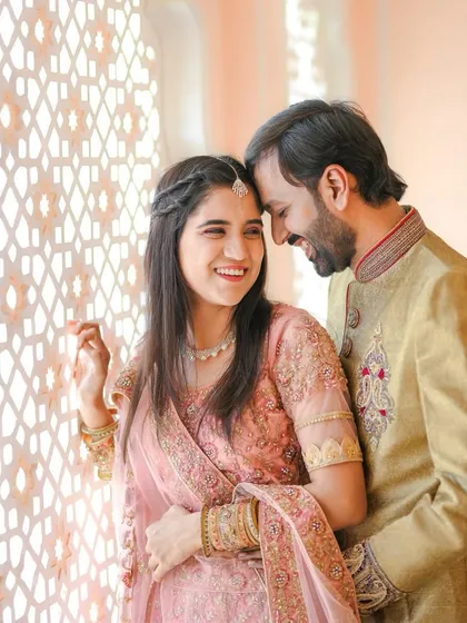 A joyful and candid close-up of the couple in their traditional attire, capturing a moment of genuine laughter and connection.