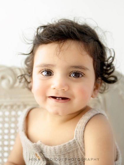 Look at that precious little toothy smile. This close up from a sitter session captures the sweet details of this fleeting stage, from the wispy curls to the sparkle in her eyes.