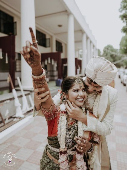 A moment of pure celebration and joy, with the bride pointing up in excitement as the groom embraces her.