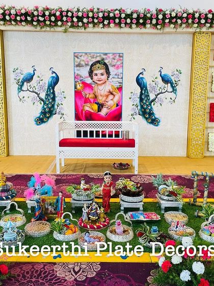 For this baby shower in Annur, the client requested a backdrop with a baby photo and peacock designs. I created a matching platter setup with custom dolls and decorations.