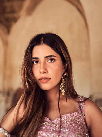 A close-up beauty shot that captures the model's features and the ornate earrings. The soft, natural lighting enhances her look, making it perfect for a bridal or festive campaign.