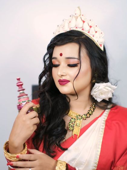 Elegance draped in red and white. A beautiful portrait of a model in traditional Bengali bridal attire, holding a 'sindoor daan' with her eyes gently closed.