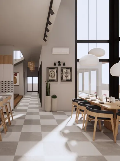 For this Goa holiday home, the dining and kitchen area is bathed in natural light from double-height windows. The checkered floor and neutral palette create a bright, airy foundation for relaxed family gatherings.
