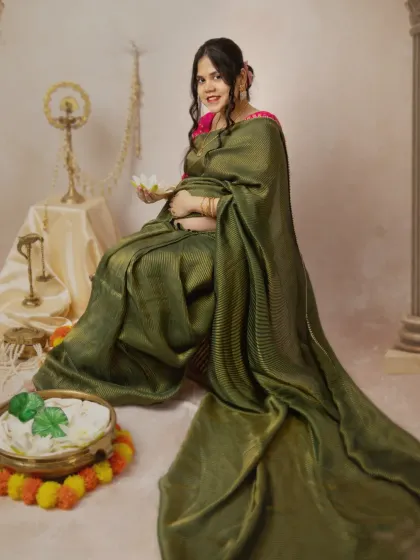 A serene solo portrait of the mother-to-be in a gorgeous green saree. She holds a lotus flower, a symbol of purity and beauty, which perfectly complements the theme of the shoot.