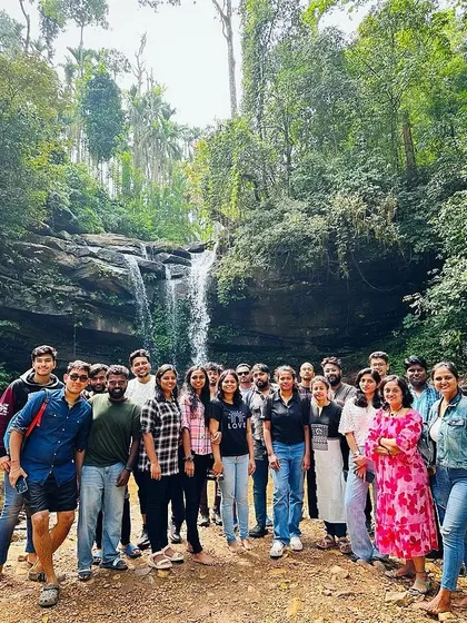 The New Year's batch posing for a group photo in front of a waterfall in Chikmagalur.