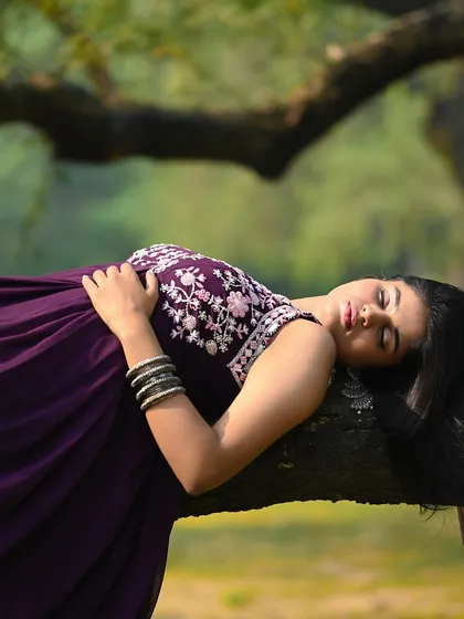 A creative and ethereal shot of the model lying on a tree branch, with her hair flowing down.
