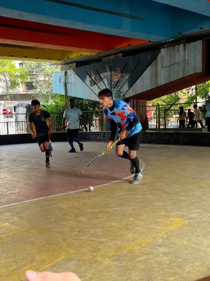 A player on the attack, dribbling at speed during a rink hockey game. This unique training space allows us to practice year-round, regardless of the weather.