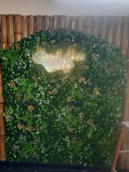 A great feature wall can make a space unforgettable. For this terrace, we created a lush green wall with a custom "Good Vibes Only" neon sign, framed by natural bamboo. It's the perfect photo corner and adds so much personality.