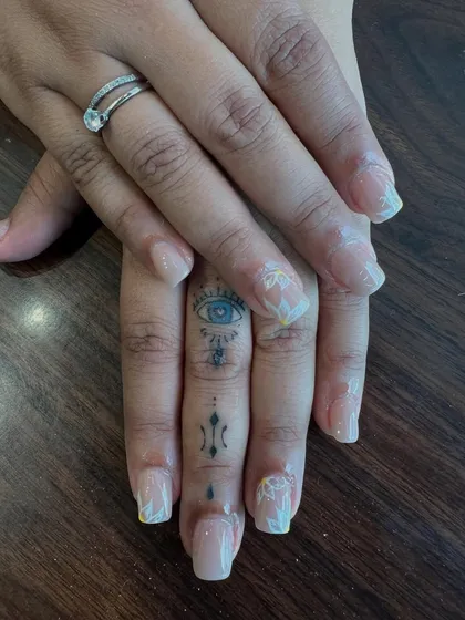 Sometimes, beauty lies in the details. This design showcases a subtle and natural look with delicate, hand-painted white floral art on a clean, translucent base. It's the perfect choice for an elegant, everyday manicure that feels personal and refined.