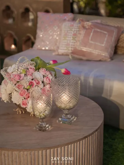 A close-up of the lounge seating, showing the fine details like sequined pink cushions and elegant floral arrangements with tulips and roses, adding a touch of glamour and romance.