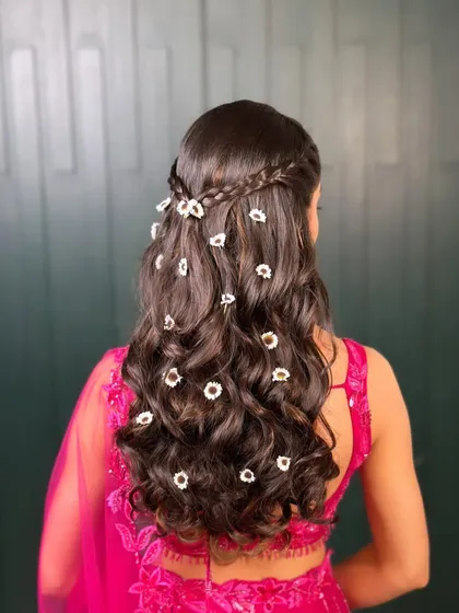 This hairstyle is perfect for a bride who wants something romantic and a little different for her mehendi. The combination of a soft braid and scattered flowers is simply beautiful.