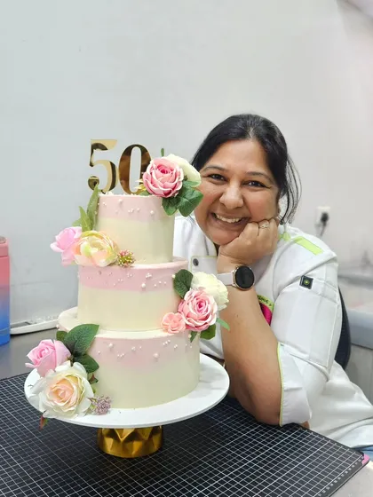 A proud moment with a beautiful 50th-anniversary three-tier cake. Elegant, floral cakes have a special place in my heart.