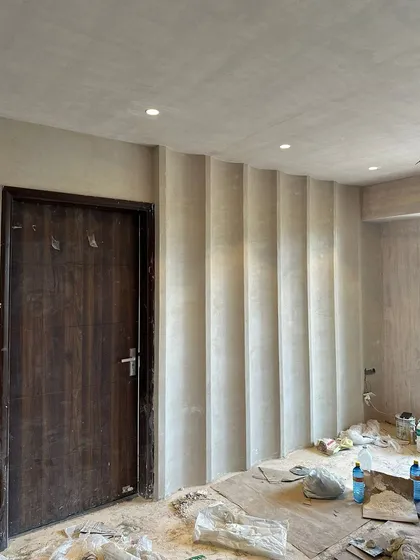 The living room wall after the application of custom vertical grooves, adding texture and dimension before the final paint.