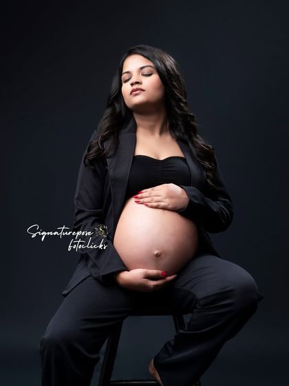 A seated portrait that feels both strong and serene, focusing on the beautiful shape of the baby bump.