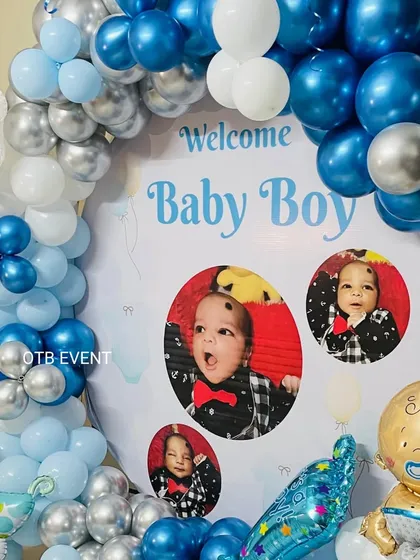 A closer look at the personalized "Welcome Baby Boy" backdrop. Including pictures of the little one makes the decoration feel so much more special and unique.