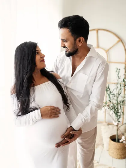 Maternity sessions are even more special when your partner joins in. This intimate moment shows a couple sharing a loving gaze, celebrating their journey to parenthood together in my bright and airy studio.