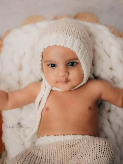 This little guy is ready for his photoshoot, posing with his teddy bear friend on a cozy, textured rug.