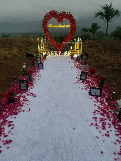 The full view of the proposal aisle, showing how we use a white runner and a thick border of red rose petals to create a grand walkway. The path is lined with the couple's memories in photo frames.
