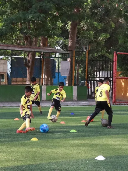 Players work on dribbling in a group, creating a dynamic and challenging practice environment.