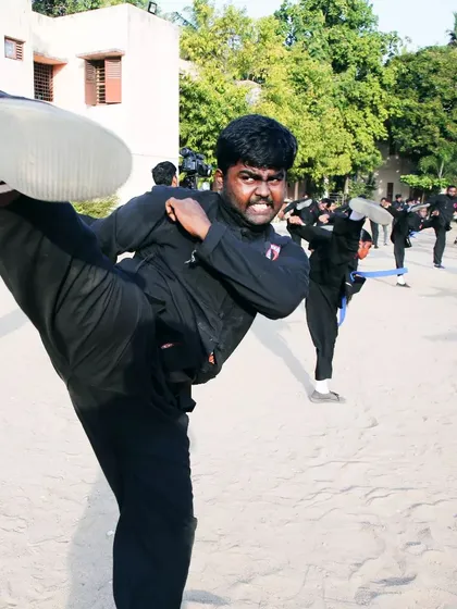 An instructor demonstrates a powerful high kick, showcasing the flexibility and strength that can be achieved through dedicated training.