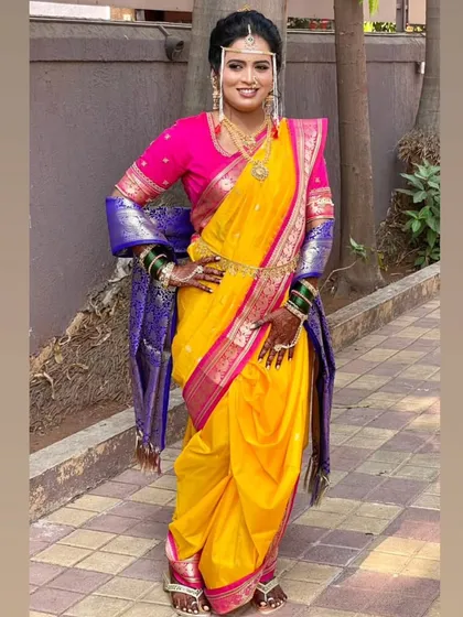 The vibrant yellow and pink of this Brahmani Navari drape captures the joyful spirit of a Maharashtrian wedding. I focus on achieving the perfect fit and fall, complete with traditional accessories like the nath and mundavalya, to create an authentic bridal look.