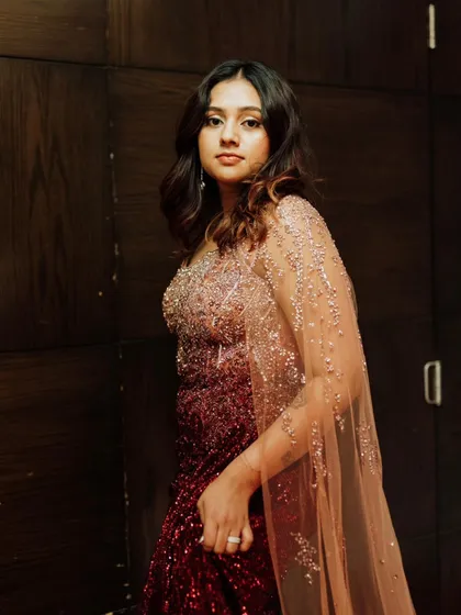 The side profile highlights the beautiful cape and the soft waves in her hair, completing the cosmic-inspired look.