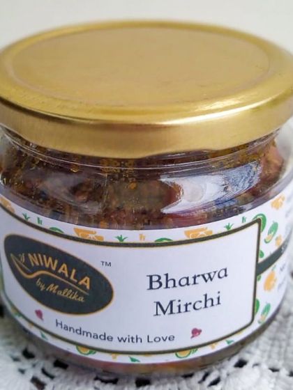 A jar of my Bharwa Mirchi, or stuffed red chilli pickle. These chillies are filled with a blend of aromatic spices, making them burst with flavour in every bite.