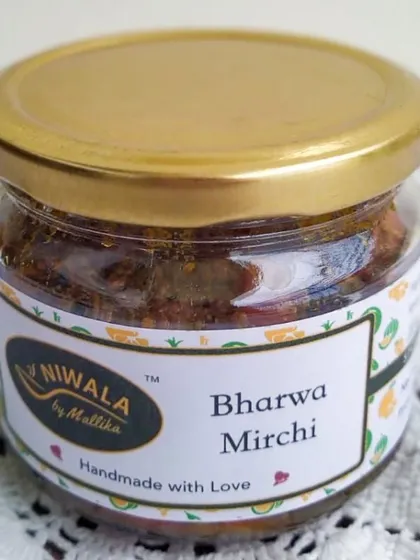 A jar of my Bharwa Mirchi, or stuffed red chilli pickle. These chillies are filled with a blend of aromatic spices, making them burst with flavour in every bite.
