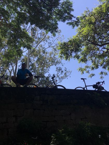A rider taking a moment to soak in the view from the top, with the bikes lined up along the wall.