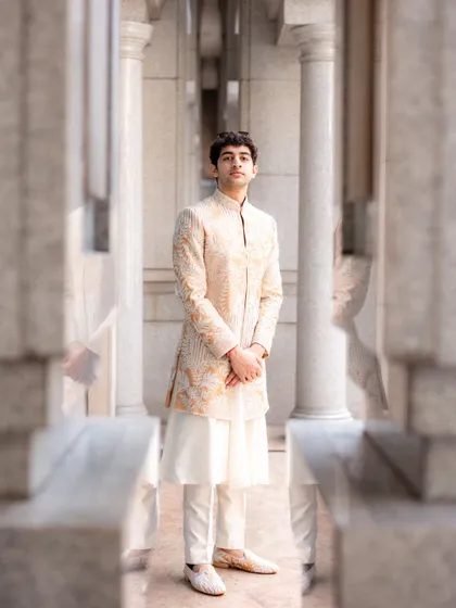 This is a perfect example of modern Indian groomswear. We chose a sophisticated embroidered sherwani in a neutral tone over a simple white kurta for the brother of the bride, creating a look that is both stylish and appropriate for the occasion.