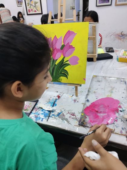 Watch the step-by-step process as a student paints a bright and cheerful bouquet of tulips on a yellow background.