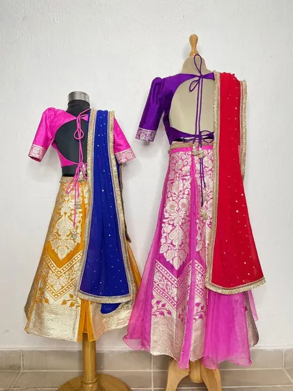A vibrant and traditional look for two sisters. I used beautiful Banarasi fabrics in contrasting colors to create these stunning lehengas, perfect for a Gujarati wedding or Navratri.