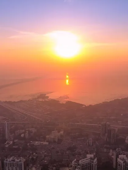 The sun rises brightly over a hazy Mumbai, casting a strong reflection on the water near the Bandra-Worli Sea Link.
