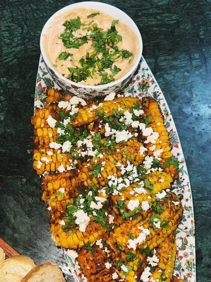 Our take on Mexican street corn, served as Elote Ribs. The corn is grilled and seasoned, then topped with feta cheese and fresh cilantro, served with a zesty dip.