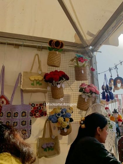 Our wall display at an exhibition, featuring hanging flower baskets and crochet tote bags. It's always a challenge to decide what to bring from our ever-growing collection!
