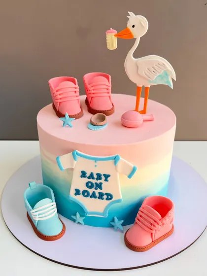 Welcoming a new arrival is a joyous occasion, and this baby shower cake captures that sweetness. It features a smooth, blended pastel frosting and is decorated with handcrafted fondant details like tiny baby shoes, a stork, and a "Baby on Board" onesie.