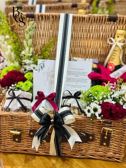 This luxurious hamper, featuring a bottle of Moët, fresh flowers, and gourmet treats in a large wicker basket, is designed to wow at first sight. It’s a perfect example of a high-end gift for a very special occasion.
