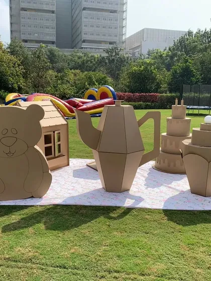 Welcome to the 'Teddy Par-Tea'. I designed this interactive play area with giant, unpainted cardboard pieces like a teapot, cake, and a teddy bear house. It provides a wonderful setup for young children to engage in creative, free play during the event.