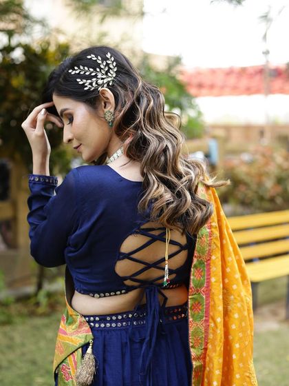 Let your hair do the talking. This beautiful open hairstyle with soft waves and a delicate hair accessory is perfect for a sangeet or engagement.